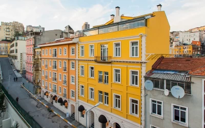 exterior-view-of-the-residential-building-having-a-historical-look-and-yellow-housepainting-alongside-the-streets-and-other-buildings