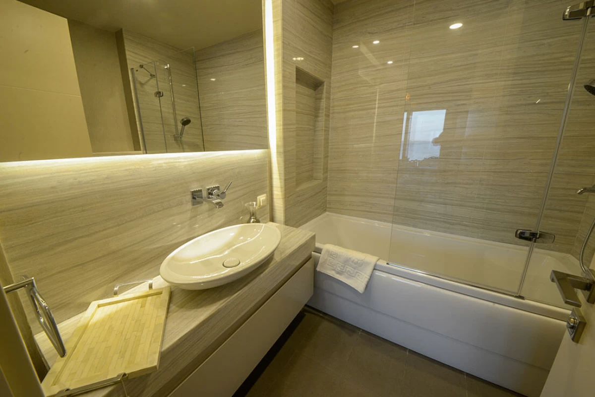 interior-view-of-the-minimalistic-and-modern-bathroom-including-a-white-bath-tub-and-full-glass-shower-cabin
