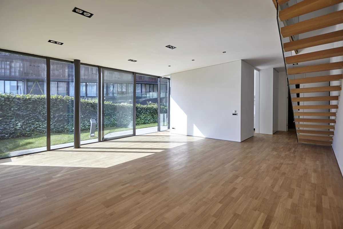 interior-view-of-the-garden-floor-apartment-having-upstairs-and-its-empty-living-room-with-floor-to-ceiling-windows