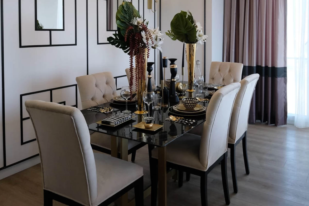 a-chic-dining-area-with-a-black-dining-table-six-white-chairs-decorative-vases-and-patterned-walls