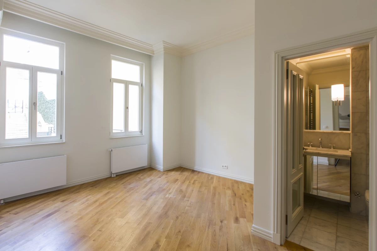 interior-view-of-the-empty-living-room-having-two-separate-windows-and-a-bathroom-with-a-turkish-bath-like-design