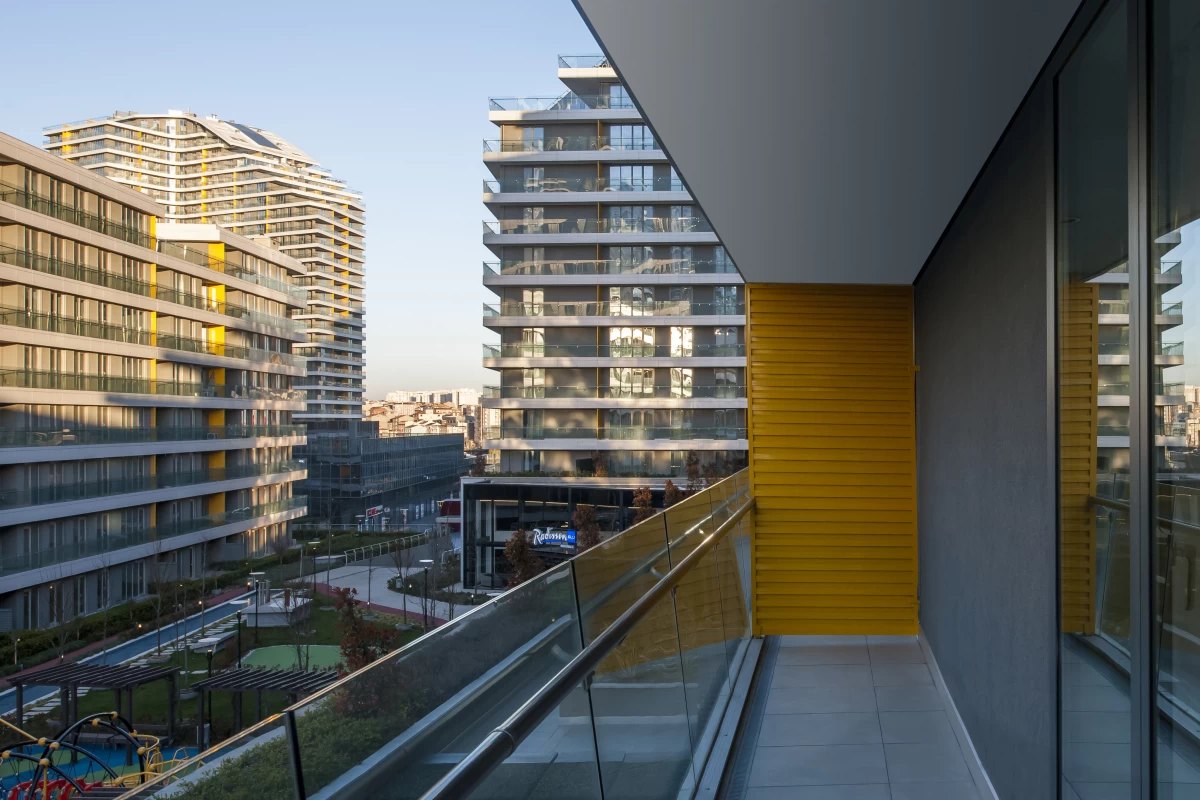 wide-balcony-of-a-residence-with-gray-and-yellow-walls-with-the-view-of-other-residences-and-garden-playing-area-and-walking-path-under-it