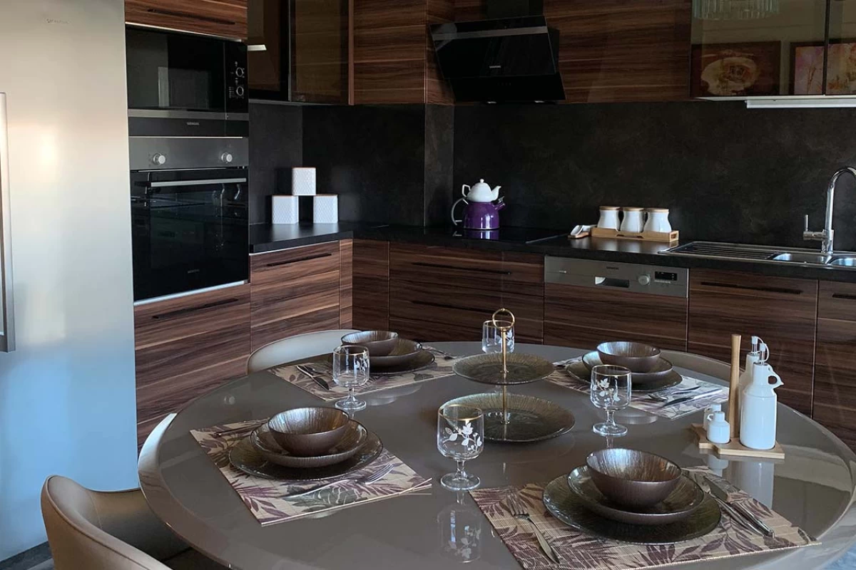 an-elegant-kitchen-design-with-dark-color-furniture-and-a-four-people-round-dining-table