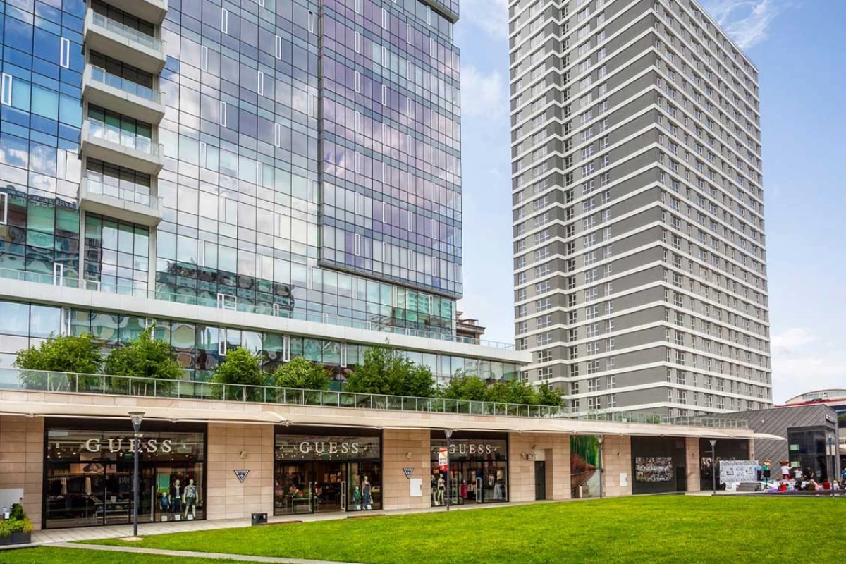 exterior-look-of-the-couple-of-buildings-with-mirror-walls-and-luxurious-commercial-units-and-green-fields-above-in-a-bright-and-sunny-day