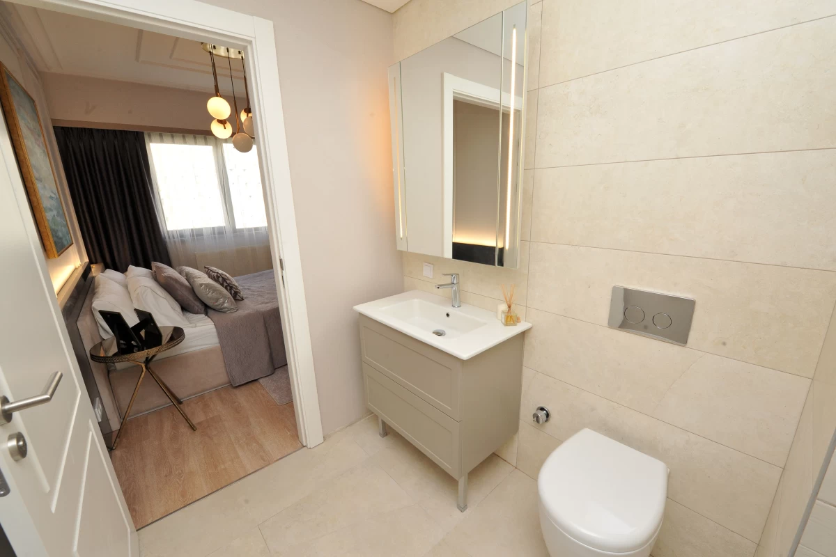 partial-view-of-a-bedroom-with-double-size-bed-and-an-en-suite-bathroom-with-a-modern-design-furnished-with-a-cabinet-mirror-and-toilet