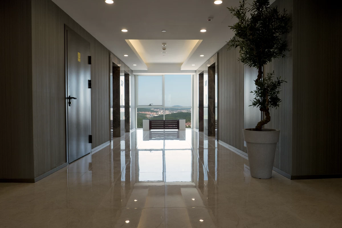 interior-view-of-the-modern-corridor-having-floor-to-ceiling-windows-and-including-four-elevators-and-private-rooms-for-staffs