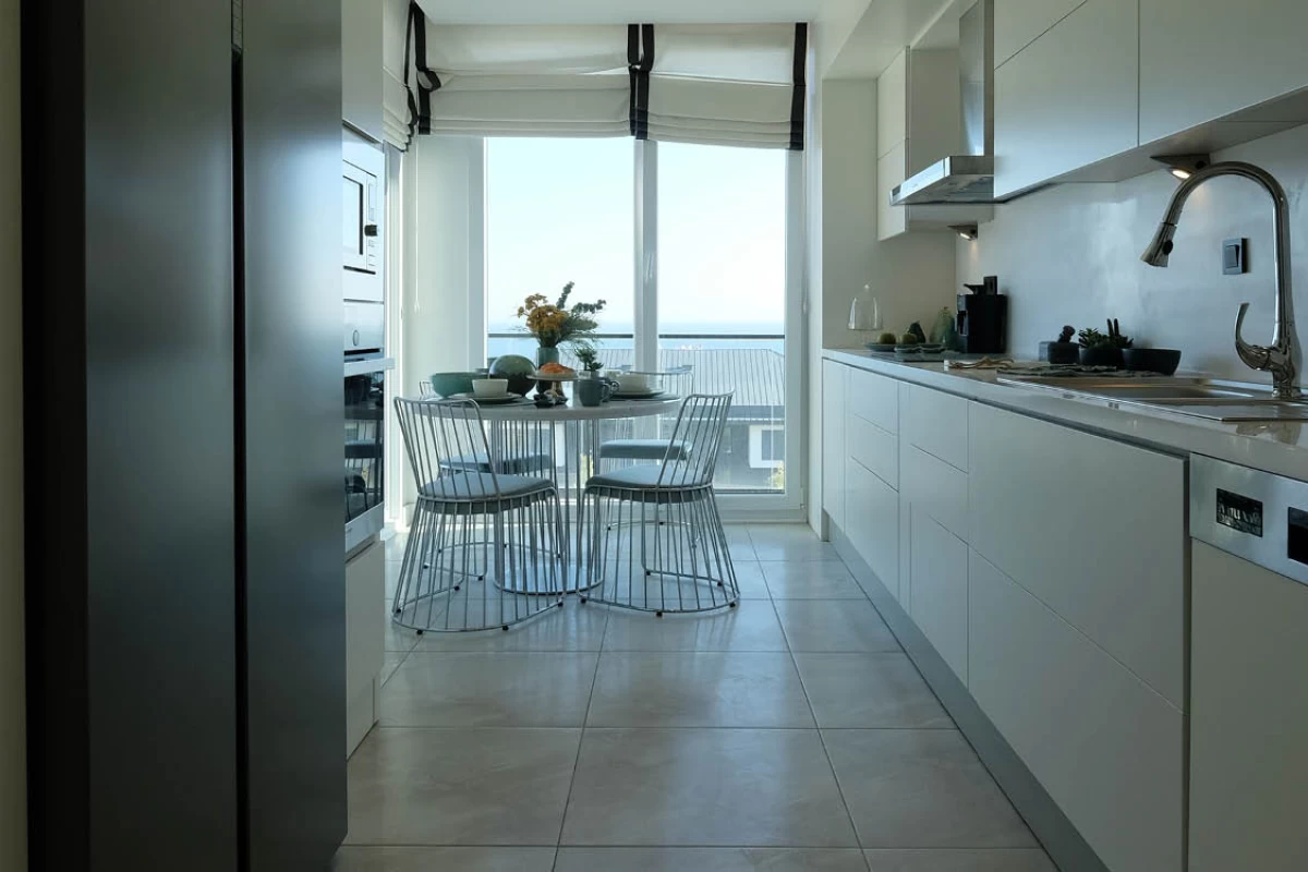a-round-dining-table-and-armchairs-in-a-kitchen-with-a-sky-view-designed-with-white-furniture