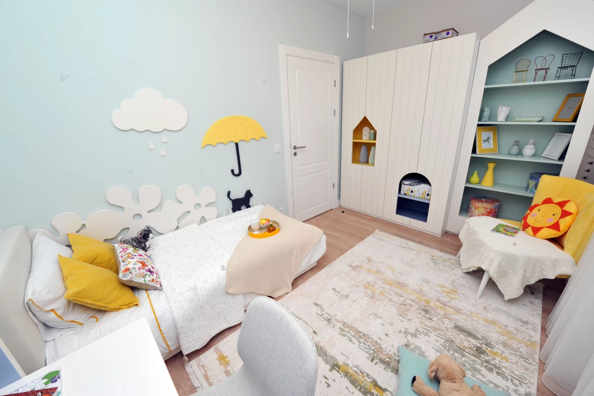 kids-bedroom-with-a-white-single-bed-carpet-white-wardrobe-decorative-library-yellow-chair-and-stickers-on-the-wall