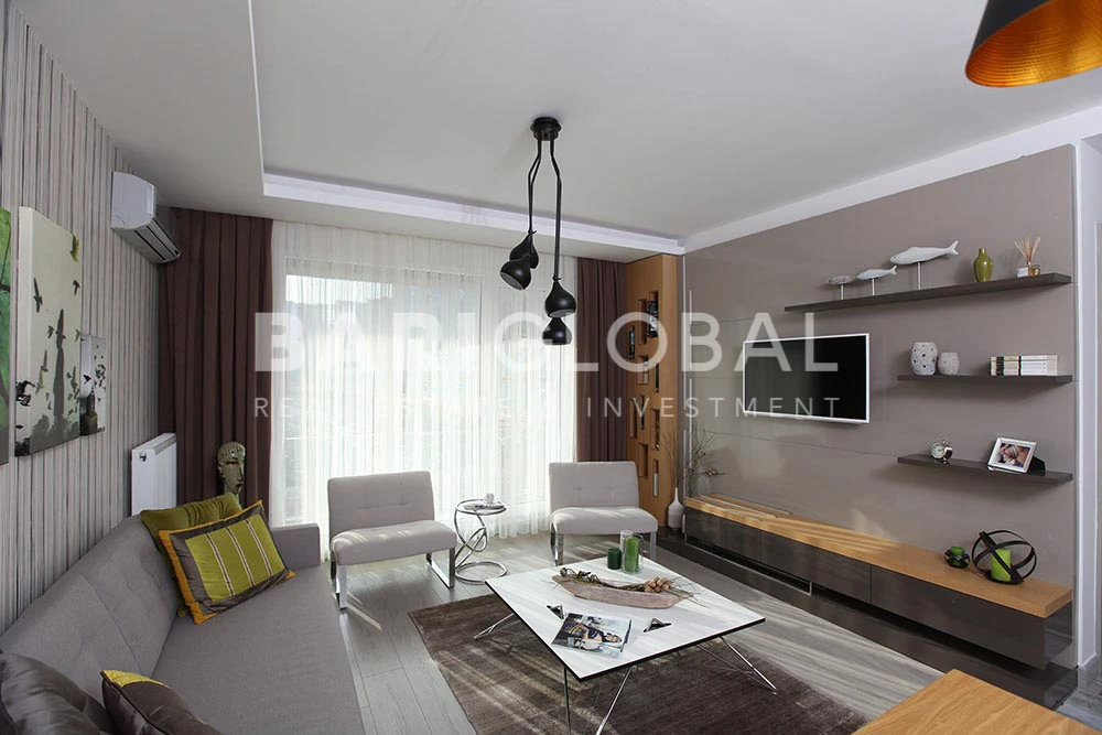 living-room-with-gray-sofa-white-armchairs-patterned-walls-a-tv-unit-black-pendant-lights-square-coffee-table-and-decorative-items